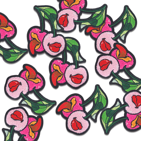 Patch featuring two cherries with expressive lips, one with a tongue sticking out, set against a white background. The design is playful and vibrant, combining bold colors with a fun, cheeky style.